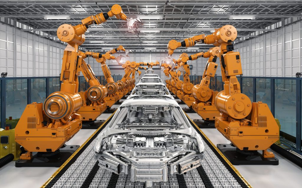  Yellow robotic arms assembling car bodies on an assembly line. 
