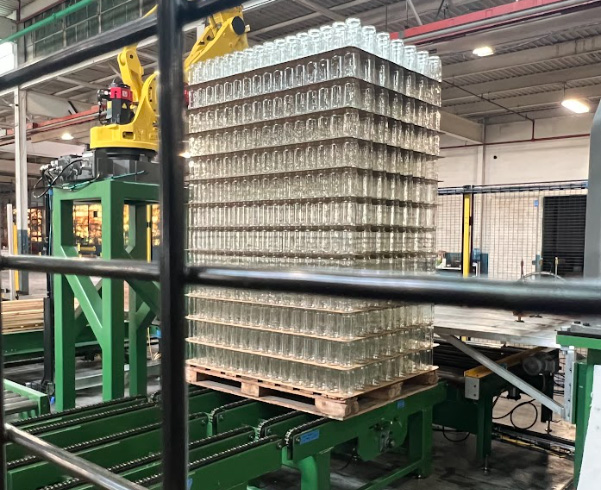 A full pallet of stacked glass bottles completed by a RōBEX machine