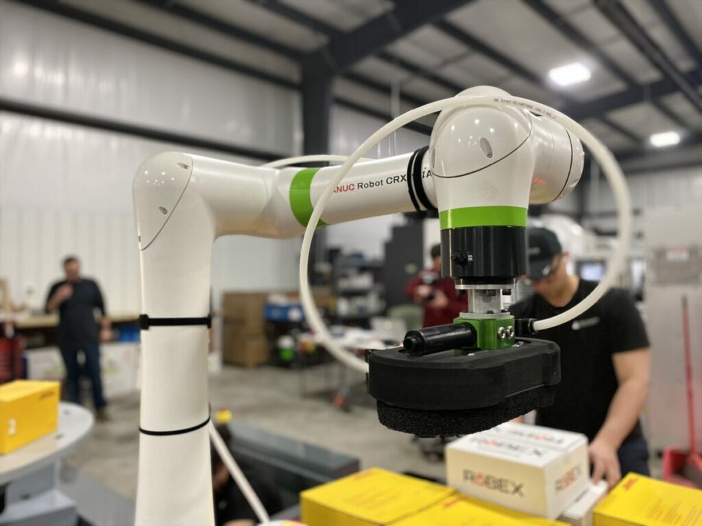 FANUC’s CRX collaborative robot with employees in the background.