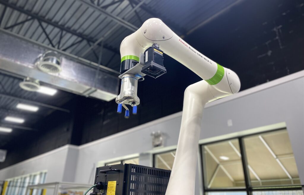 FANUC’s CRX collaborative robot arm is in a factory.